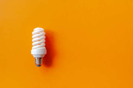 Energy saving light bulb on a orange backgroundの写真素材