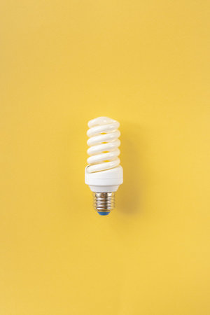Energy saving light bulb on a yellow background