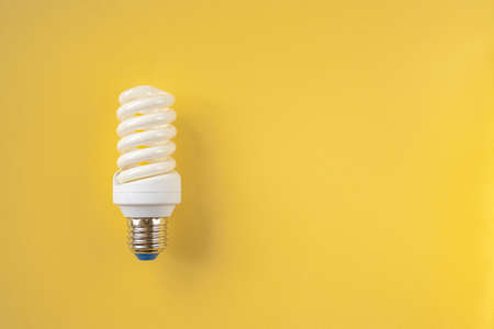 Energy saving light bulb on a yellow backgroundの写真素材