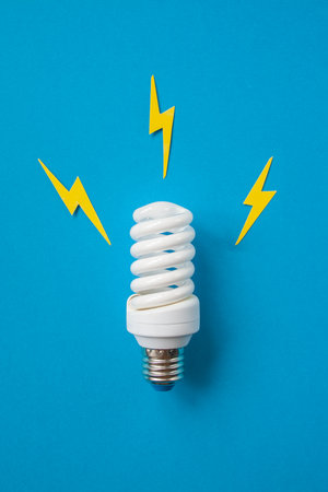 Light bulb with energy lightings on blue backgroundの写真素材