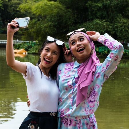 Girls just wanna have fun! Two female friends, tourists, taking a selfieの写真素材