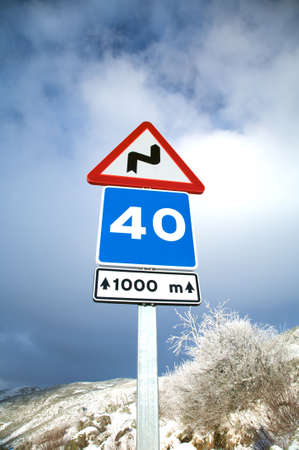 speed and dangerous curve sign on a snow roadの写真素材