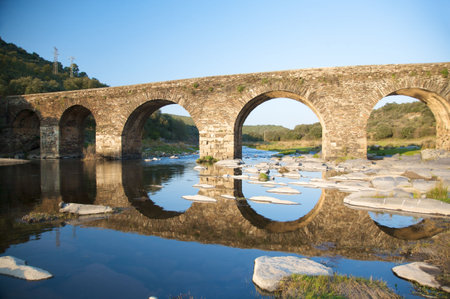 ancient stone bridge on a river in salamanca spainの写真素材