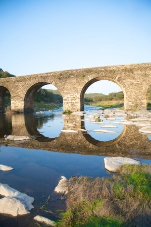 ancient stone bridge on a river in salamanca spainの写真素材