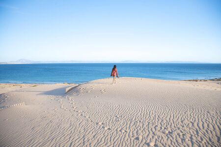 woman at sand dune in spain with african horizonの写真素材