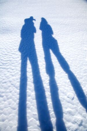 two silhouettes of couple on snow and ice groundの写真素材