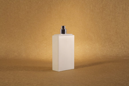 white spray bottle on golden textured paper at still lifeの写真素材