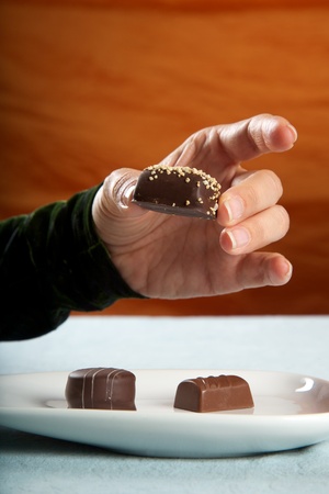 detail of woman eating brown bonbonの写真素材