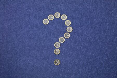 one euro coins as a question mark on blue background の写真素材