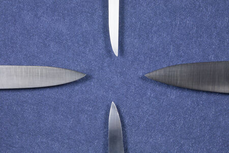 four big kitchen knife bright silver blades on blue backgroundの写真素材