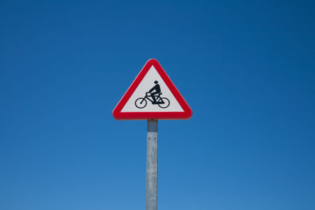 metal pole with triangle traffic signal advice cyclist or bikes on road in urban street in Madrid...