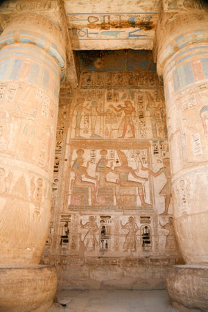 Egyptian paintings, carving figures and hieroglyphs in columns and wall of landmark Temple of Ramses...