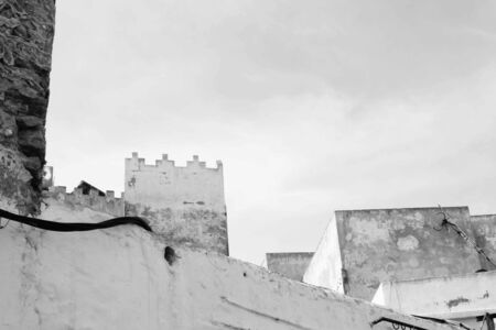 This black and white composition places the diagonal of the nearer wall against the ramparts of the tower behind.の写真素材