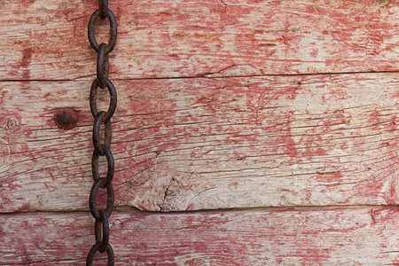 Rusty chain on old boards background and worn paintの写真素材