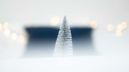 Christmas tree made of snow on a white background with bokeh.の写真素材