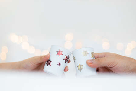 Hand holding Christmas cup with bokeh light background. Christmas and New Year concept.の写真素材