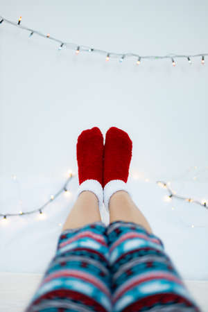 Legs of a woman in socks on the background of Christmas garlandの写真素材