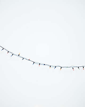 Colorful Christmas lights on a white background. Selective focus.の写真素材