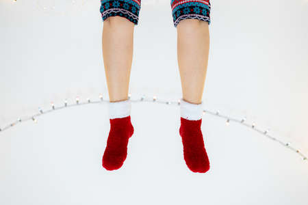 Female legs in red socks on a white background. Christmas concept.の写真素材