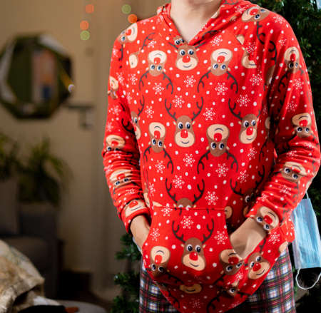Woman in red pajamas with a Christmas tree in the background.の写真素材