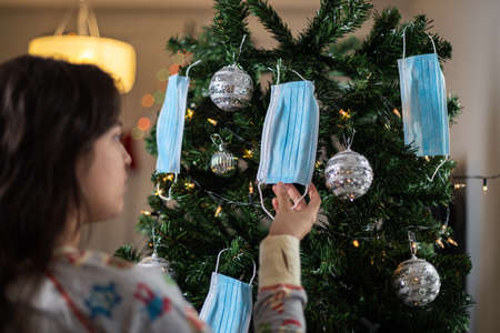 Girl in pajamas decorates the Christmas tree.の写真素材