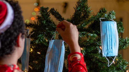 Hands of a man and a woman decorate the Christmas tree.の写真素材