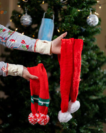 Close up of female hands wearing Santa Claus clothes and holding knitted socksの写真素材