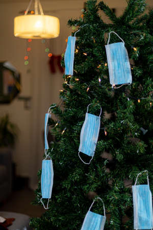 Christmas tree decorated with medical masks and garlands. New Year and Christmas concept.の写真素材
