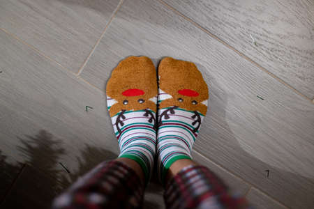 Feet in Christmas socks on the floor. Christmas and New Year concept.の写真素材