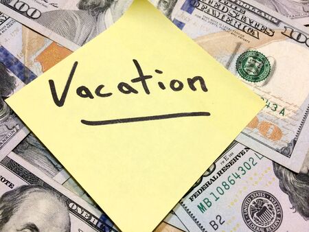American cash money and yellow paper note with text Vacation in black color aerial viewの写真素材