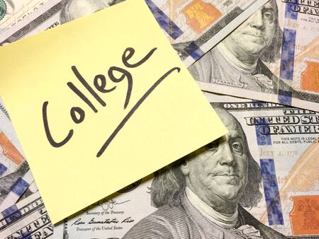 Post it note with hardwritten college on money straight on view with text space on rightの写真素材