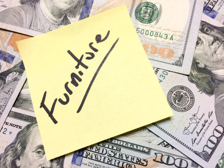 American cash money and yellow paper note with text Furniture in black color aerial view