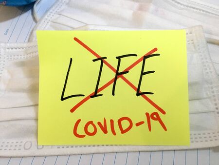 Coronavirus COVID-19 infection life dead deceased COVID respiratory disease influenza effect on surgical mask and earth globe backgroundの写真素材