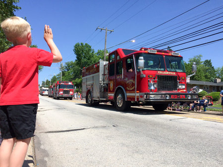 boy and firetruck at july 4 parade waving at fire truck and firemen