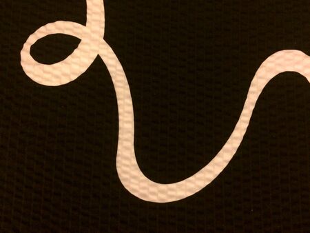 Curved graphic white gold squiggly line on black backgroundの写真素材