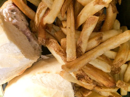Chicken salad sandwich with french fries on french roll bread