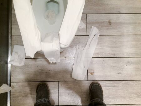 messy public restroom with toliet paper all overの写真素材