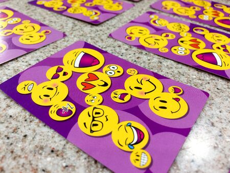 Happy face smiely emoji on playing cards purple color on tableの写真素材