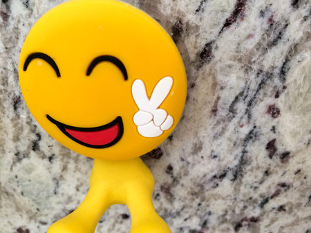 Happy fun yellow smiling emoji couple with peace sign dental toys