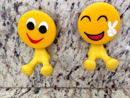 Happy fun yellow smiling emoji couple with peace sign dental toysの写真素材