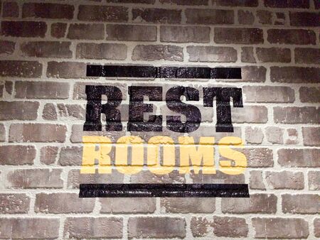 Restroom text for public bathroom sign on brick wall indoorsの写真素材