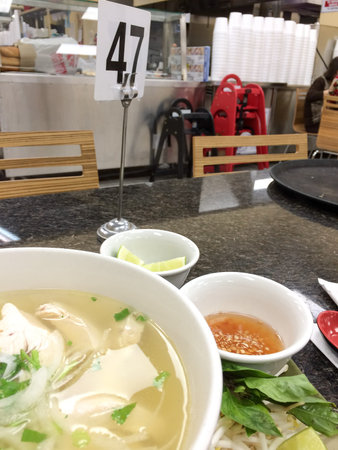 Vietnamese pho chicken noodle soup on tray at restaurant