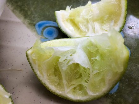 Used squeezed bright green lime slices on tableの写真素材