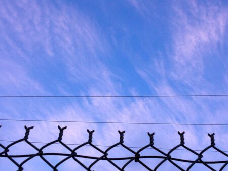Blue sky cloud chain link fence background design element patternの写真素材