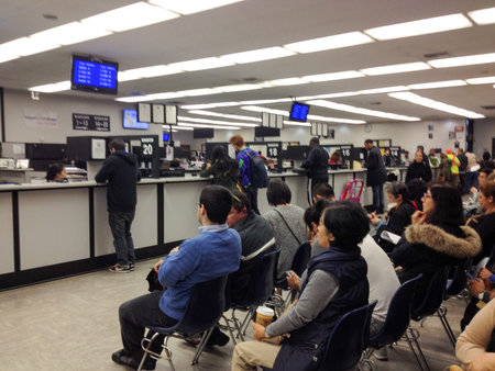 Department of motor vehicles DMV California America people waiting in crowded line indoor government...