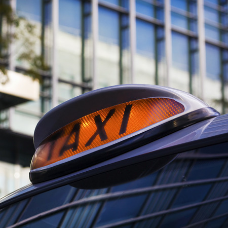 Taxi sign on Cab in Canary Wharf, Londonの写真素材