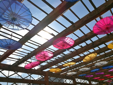 Colorful paper umbrella hanging on wooden structureの写真素材