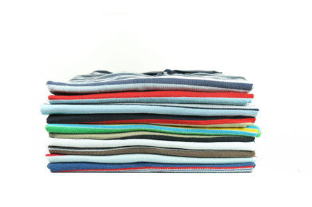 Stack of colorful cross-striped t-shirts over white backgroundの写真素材