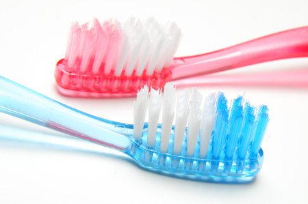 Two colorful toothbrushes on white background