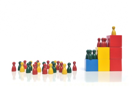 Hierarchy - Multicolored wooden toy blocks and figures on white backgroundの写真素材